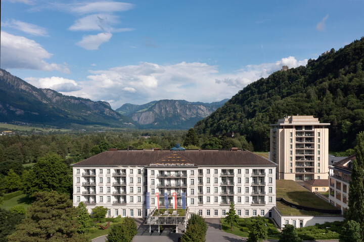 Das Hotel Quellenhof von vorne und leicht oben mit Spa Tower und Bergen im Hintergrund. Es gehört zu dem Grand Resort Bad Ragaz.