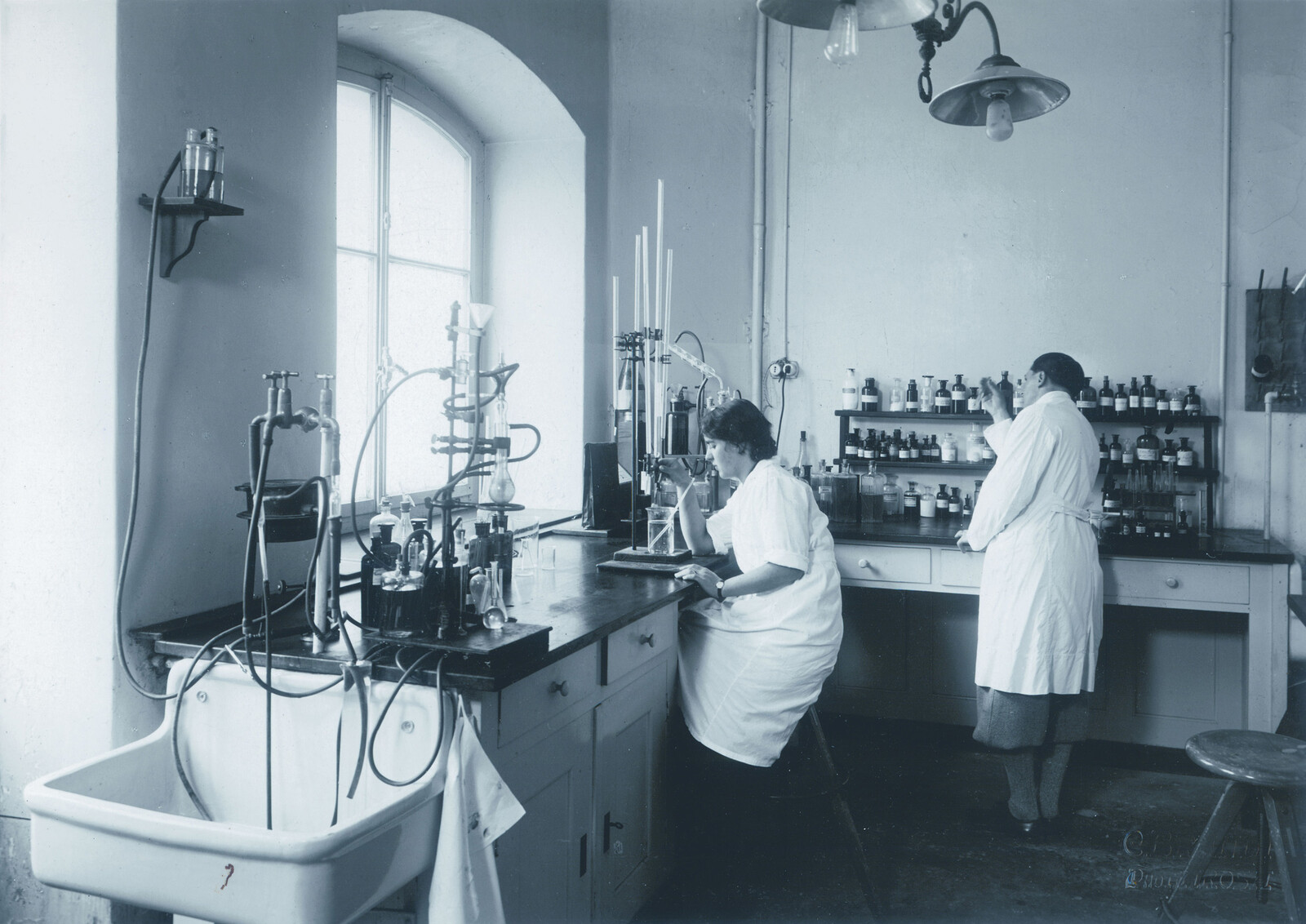 Das MHC Labor von 1959 wird gezeigt. Zwei Damen arbeiten darin. Das Labor gehört zum Grand Resort Bad Ragaz, einem Sterneresort in der Schweiz.