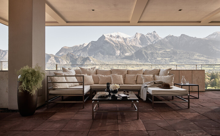 Luxuriöse Terrasse der Penthouse Suite mit eleganten cremefarbenen Sofas, einem zentralen Couchtisch und Blick auf die Berge. Die Atmosphäre ist ruhig und einladend, Komfort und Natur stehen im Vordergrund.