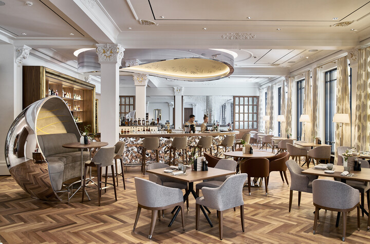 Die Bar Verve ist hinter den Tischen des Restaurants zu erkennen. Sowohl die Bar, als auch das Restaurant gehören zum Hotel Grand Resort Bad Ragaz, einem Sternehotel in der Schweiz.