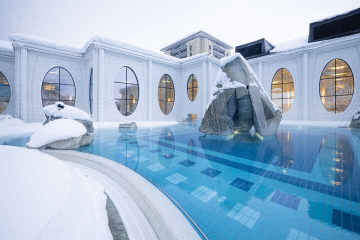 Schnee bedeckt das Becken des Aussenbads der Tamina Therme im Winter. Die Tamina Therme ist angebaut an das Hotel Grand Resort Bad Ragaz, einem Superior Sternehotel in der Schweiz.