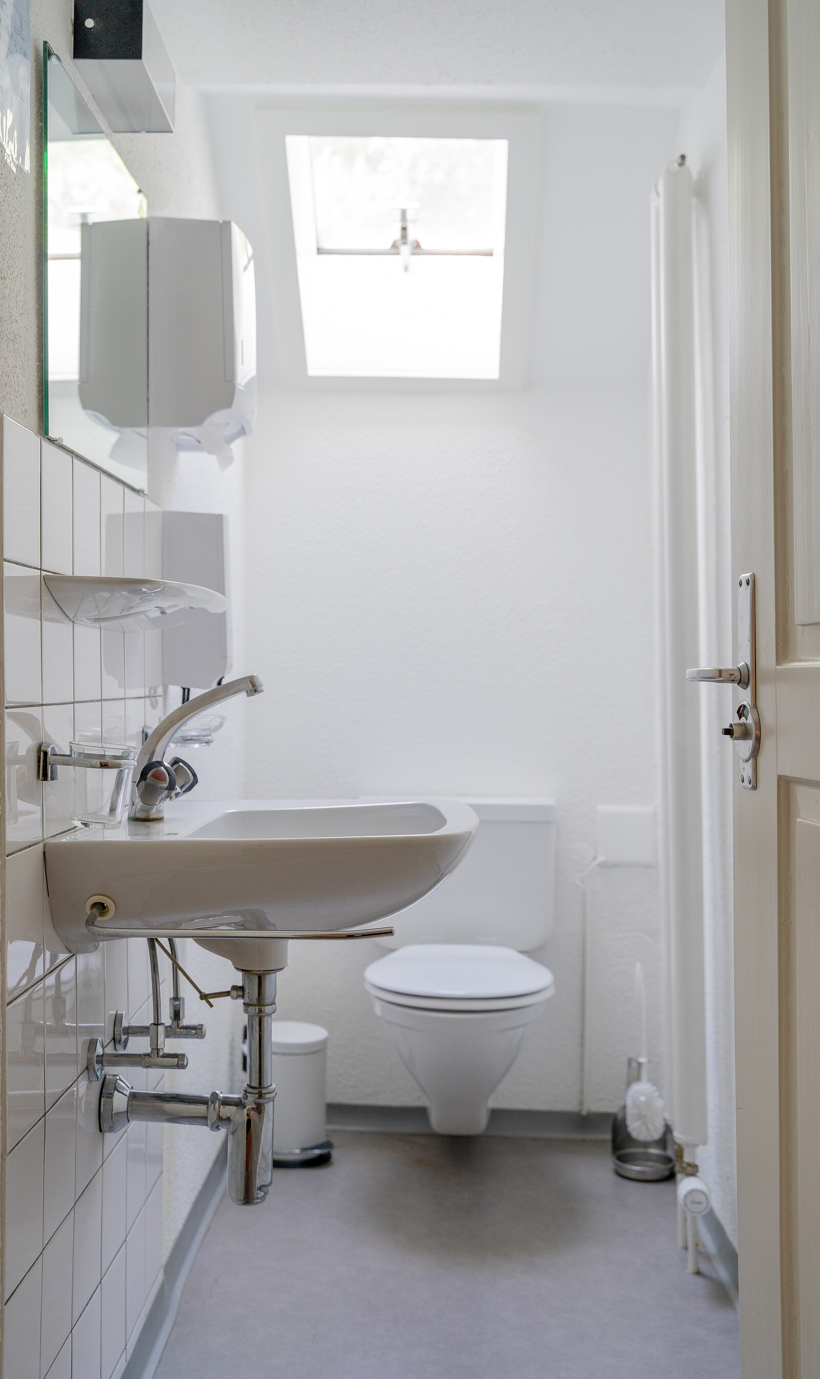 The bathroom of the Solitude staff house shows a toilet and a sink. The staff house is part of the Hotel Grand Resort Bad Ragaz, a star hotel in Switzerland.