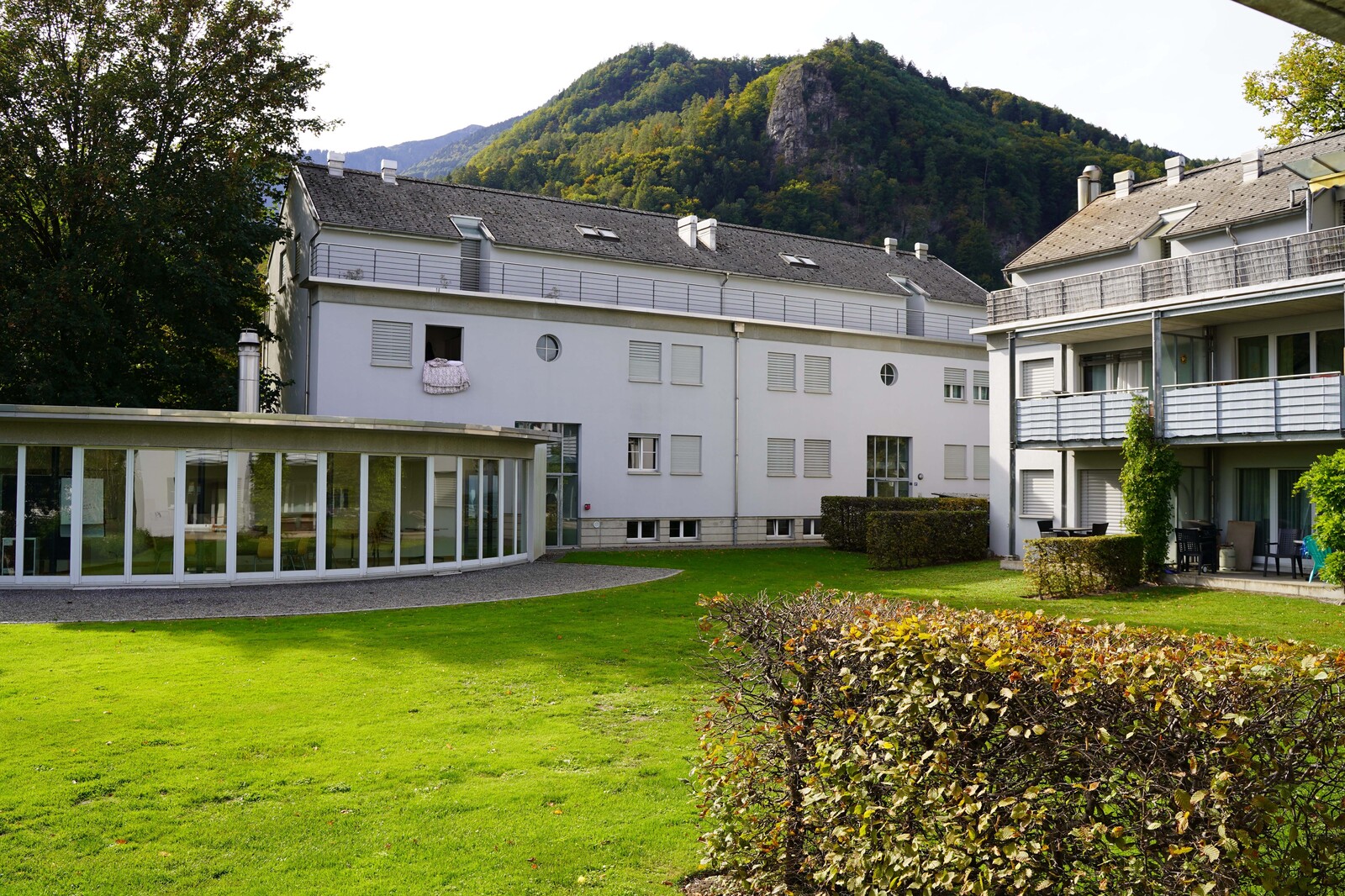 The garden of the staff house on Taminastrasse in Bad Ragaz can be seen. A pavilion is on the left. The staff house is part of the Hotel Grand Resort Bad Ragaz, a star hotel in Switzerland.