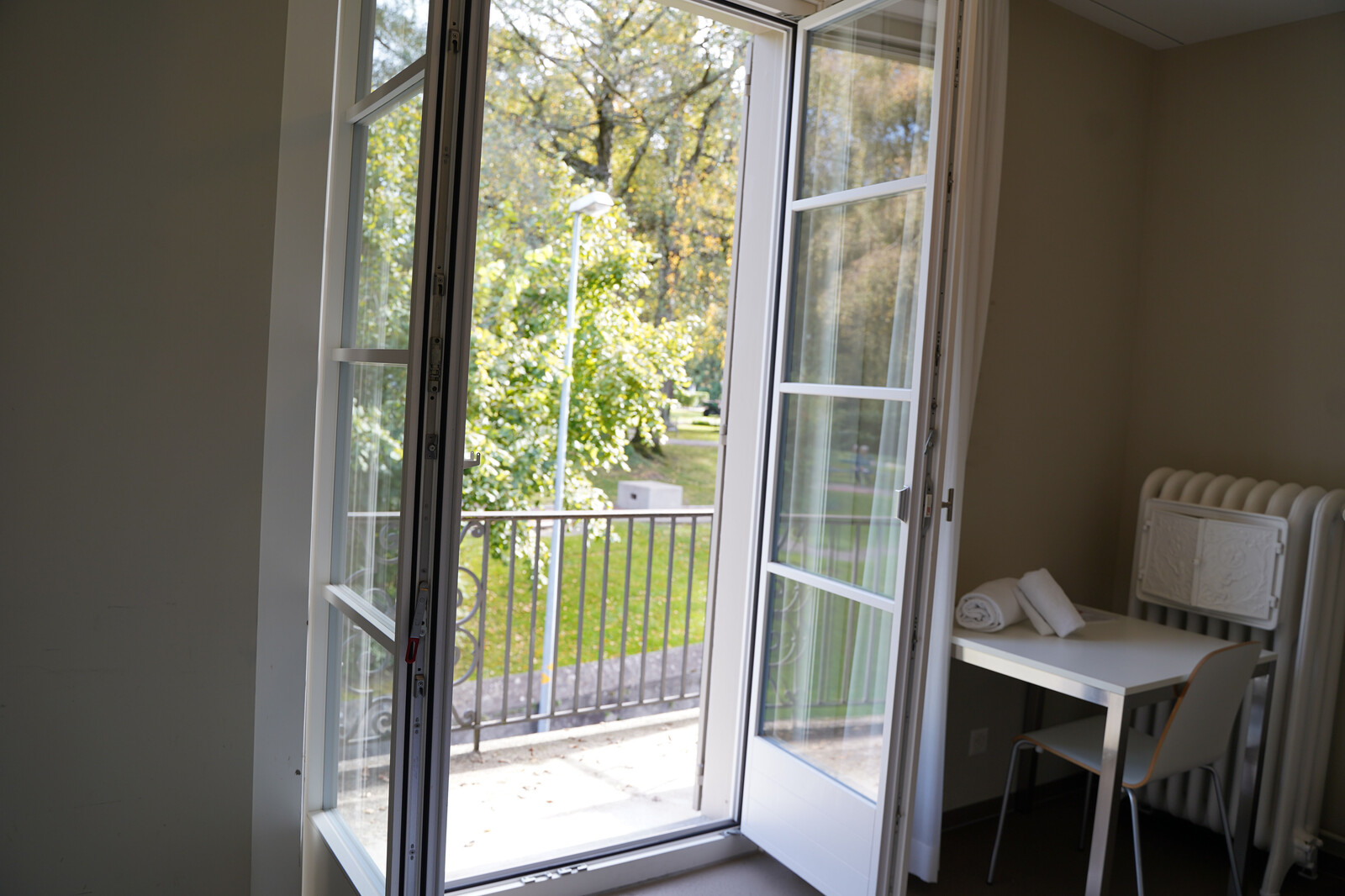 The door to the garden in the Sarona staff house is open. There is a terrace behind the garden door from which you can see the Hotel Grand Resort Bad Ragaz.