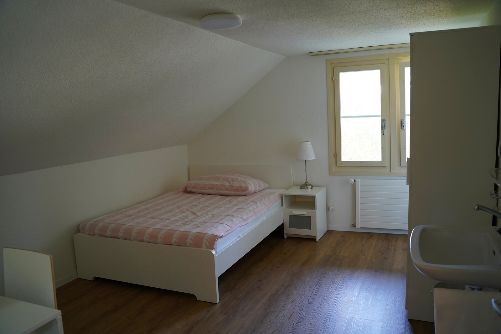 A separate staff house on Hermitageweg in Bad Ragaz is available for the female employees of the Grand Resort Bad Ragaz. This room is equipped with a bed, a window, closet, washbasin and table with chair.