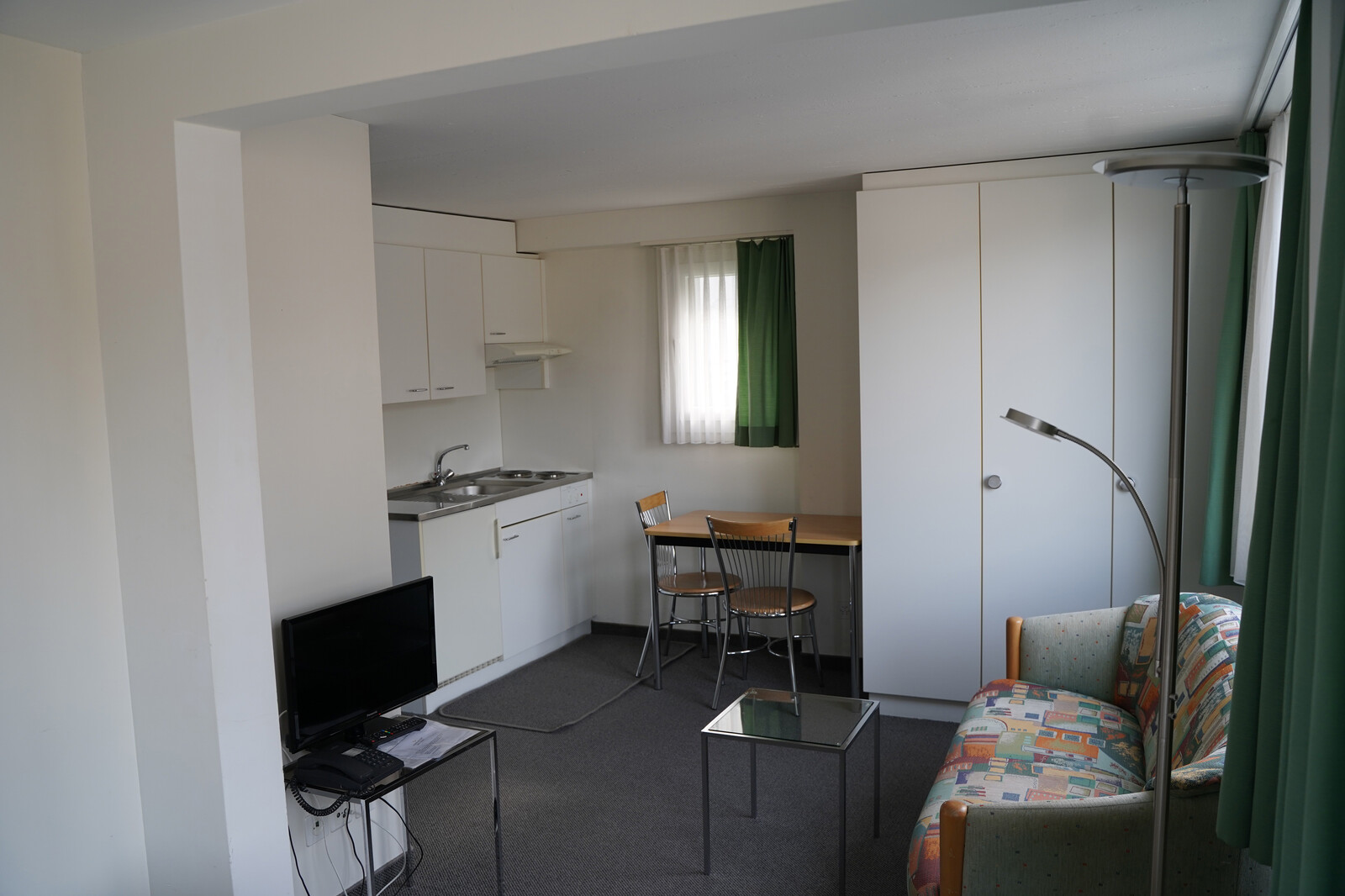 The studio's kitchen is visible. The studio is located in the Pfäfeserstrasse staff house of the Grand Resort Bad Ragaz.