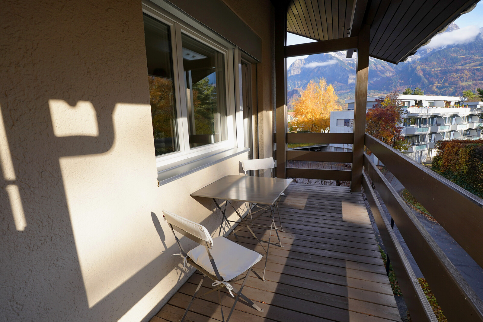 Das Personalhaus Maienfelderstrasse in Bad Ragaz wird gezeigt. Die Wohnungen und Studios gehören zum Grand Resort Bad Ragaz. Hier wird der Balkon mit Tischen und Stühlen gezeigt.