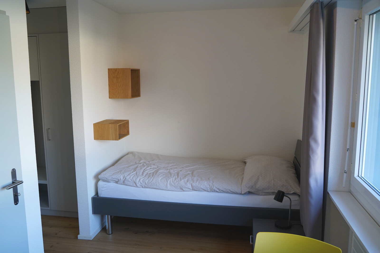 The picture shows the bed in the Blumenrainstreet studio. The staff house belongs to the Grand Resort Bad Ragaz.