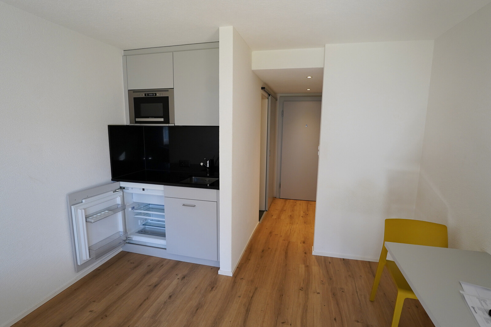 Die Küche des Studios befindet sich auf der linken Seite. Der Esstisch ist auf der rechten Seite. Das Studio gehört zu dem Personalhaus in der Blumenrainstrasse. Dieses befindet sich in Bad Ragaz und ist zugehörig zu dem Grand Resort Bad Ragaz.